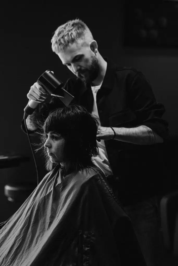 Marco Stauber föhnt einen organisch geschnittenen Damenhaarschnitt – natürlicher Fall, Friseursalon Röthenbach (s/w)